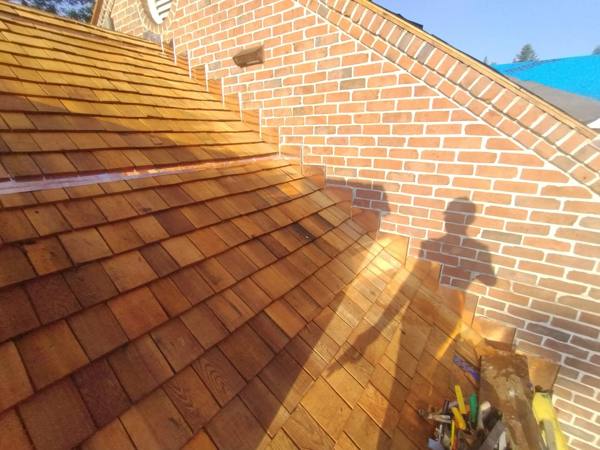 Copper step flashing where cedar shake meets brick